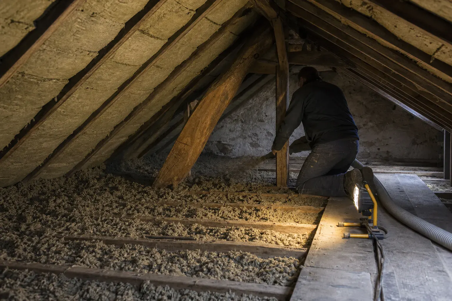 Laine minérale posée entre chevrons et isolant soufflé étalé sur le plancher de comble